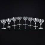 VIDRO, oito (8) taças de pé alto para vinho tinto, incolores e translúcidas, bojo com singela lapidação vegetalista, fuste no formato de balaustre, base em bolacha, medindo 12 cm altura, sinais de uso, vide foto.