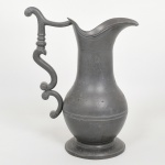 PEWTER, uma (1) jarra padrão inglês georgiano, bojo com mossas, punção de manufatura parcialmente legível, medindo 30 cm altura mais o prolongamento da alça, sinais de uso, pequenas perdas, vide foto.