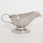 AÇO INOX, uma (1) molheira de pé baixo, lisa, alça curvilínea, manufatura WOLFF (tradição desde 1894), medindo 19 cm comprimento, sinais de uso, vide foto.