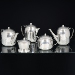 AÇO INOX, baixela para chá e café com cinco (5) itens: 2 bules; 1 cremeira; 1 açucareiro e 1 manteigueira, lisas, tampas esféricas, manufatura FRACALANZA (tradição desde 1884), medindo a maior peça 15,5 cm altura, sinais de uso, vide foto.