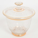 VIDRO, uma (1) bomboniere com tampa, incolor e translúcida, ornada com primorosa lapidação em elementos vegetalistas, arremates a ouro, medindo 16 cm altura e 15 cm diâmetro, sinais de uso, vide foto.