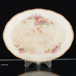 FAIANÇA INGLESA, uma (1) travessa oval, ornamentação floral policromada, arremates a ouro, borda recortada, marca WOODS IVORY WARE (usada nas décadas de 30 e 40 pela Wood & Sons, fundada em 1865, funcionou na Potteries New Wharf em Trent e mais tarde na Pottery Stanley em Burlem, fechou em 2005), possui o craquejado característico do envelhecimento de toda a faiança, além de manchas, medindo 27,5 x 21 cm, sinais de uso, vide foto.