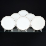 PORCELANA, seis (6) pratos para sobremesa, tonalidade branca, arremate com friso prateado, medindo 17,5 cm diâmetro mais as alças, modelo MEDAILLON, manufatura RENNER (Porto Alegre, RS, fundada em 1942; em 1998 foi vendida para a Vista Alegre de Portugal; em 1999 mudou a razão social para Vista Alegre do Brasil), íntegros, sinais de uso, vide foto.