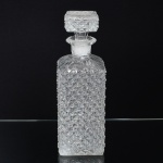 VIDRO, uma (1) licoreira retangular, incolor e translúcida, modelagem em caneluras e bico de jaca, fundo estrelado, medindo 25 cm altura, sinais de uso, vide foto.