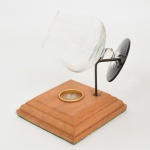 CRISTAL, uma (1) taça para conhaque, incolor e translúcida, fuste quase esférico, base em bolacha overlay na tonalidade preta, fundo estrelado, medindo 11,5 cm altura, acompanha suporte com base em madeira, possui queimador central e haste metálica para encaixar a taça, sinais de uso, vide foto.