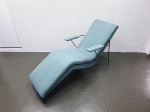 "Chaise Hauner com estrutura em ferro, tapeçaria em tecido azul e detalhes em latão. Medidas: 66
