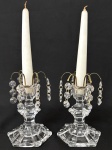 Graciosos castiçais em denso cristal translucido, ornados com ganchos em metal e penduricalhos. Acompanha velas. Mede 15cm.