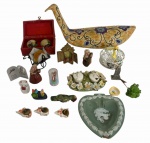 Lote decorativo com objetos diversos, composto por ave decorativa em cerâmica policromada, caixa forrada contendo esferas pintadas à mão, castiçais, pequenas esculturas e bibelôs em porcelana, resina e metal, miniaturas, porta-velas, prato em formato de coração com decoração em relevo, peças religiosas e itens de fantasia. Conjunto variado para decoração e coleção. No estado. Total de 20 peças, medida da maior 30cm.