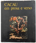 Livro Cacau em Prosa e Verso, organização de Hélio Pólvora e Telmo Padilha, Edições Antares. Exemplar com dedicatória e assinatura manuscrita, tornando a peça especial para colecionadores e interessados em literatura brasileira e temática do cacau. Capa com desgastes do tempo e miolo preservado, conforme imagens. Mede 28 x 24 cm.