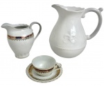 Lote de porcelanas, composto por duas leiteiras e xícara de café com pires, em porcelana branca com decoração em dourado vibrante. Xícara marcada Porcelana Steatita  Paraná. Uma das peças possui fio de cabelo. Medida da maior: 19 cm.