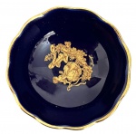 Pequena tigela em porcelana francesa Limoges, na cor azul-cobalto com borda ondulada realçada a ouro. Centro decorado com motivo clássico em douração. Marca na base Limoges  Made in France  Peint à la main. Mede 7cm.