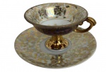 Xícara de café e ou coleção com pires em porcelana Mauá, decoração iridescente em tons nacarados com rica ornamentação floral em dourado e base elevada dourada. Meados anos 50.