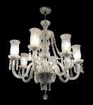 Lustre de cristal, estilo clássico, com 8 braços, estrutura em vidro trabalhado, bobeches e mangas lapidadas, pingentes em cristal e corrente decorativa superior. Peça elegante, de forte presença decorativa, ideal para salas de estar ou jantar. Mede 80 x 75 cm.