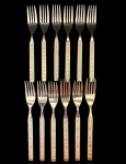 JAPÃO - Conjunto com 12 garfos de mesa em aço inox dourado, cabos decorados em relevo com motivos florais. Peças marcadas Stainless by Dresser  Japan, acompanhando estojos plásticos originais. Mede 19 cm.