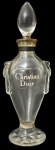 Frasco de perfume antigo Christian Dior, em vidro translúcido moldado, com inscrição frontal da marca. Corpo elegante com pequenas alças laterais estilizadas, base facetada em forma de estrela e tampa original em vidro lapidado. Peça de tocador de estética clássica, provavelmente meados do século XX. Mede 17cm de altura.