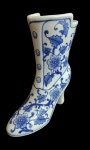 Diferente floreira de porcelana em forma de bota com lindos florais azul e branco. Medidas 18cm altura.