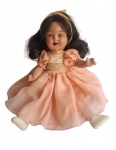 Antiga boneca de massa, representando Shirley Temple, de 1940 , com cabelos cacheados e vestido rosa pêssego. Os olhos abrem e fecham. A boga é aberta. Apresenta uma pequena perda na íris do olho esquerdo. Medidas 33 cm. Lote vendido no estado.