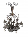 Antigo e grande lustre em metal trabalhado, com 12 pontos de luz, base das lâmpadas em vidro. Apresenta perdas de adereços. Lote vendido no estado.