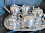 Conjunto "Fracalnaza" composto por bule café/ bule chá/ leiteira/ açucareiro/ mantegueira e bandeja, em inoxidável. OBS : falta bolinha pegador da tampa açucareiro.