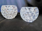 Conjunto c/ 2 porta velas em pesado cristal c/ lapidação bolha em baixo relevo.  Maior 9 cms alt X 13 cm diametro, menor 8 cm alt X 10 cm diametro.
