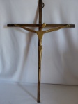 Crucifixo de parede com figura de Cristo estilizada em bronze. Medidas: 44 cm de altura x 28 cm.