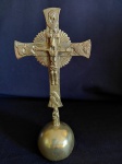 Crucifixo de mesa estilo neobarroco em bronze, com detalhes simbólicos nas extremidades, sobre base esférica. Medidas: 21 cm de altura x 6 cm de diâmetro da base.