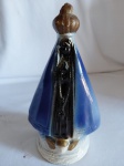 Imagem de Nossa Senhora Aparecida em porcelana com manto azul esmaltado. Medidas: 18 cm de altura.