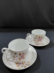 2 xícaras chá em porcelana esmaltada com desenho de flores e friso dourado próximo a borda. "Porcelana Real"