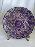 Prato decorativo estilo Satsuma com fundo esmaltado em azul cobalto e rico acabamento em ouro e relevo. Seu desenho cria uma mandala em motivos florais e   arebescos. "Made in China". Diam. 25cm