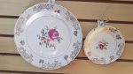 2 pratos decorativos em porcelana "Rede" na cor branca. Ramo de flores ao centro. Filete e desenhos em torno na cor ouro. Maior - 24 cm diametro. Menos - 15 cm diametro.