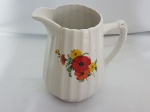 Antiga leiteira em porcelana canelada c/ decalque de flores na área frontal. 17 alt. x 10 cm, diam. base - Porcelana Vera Cruz