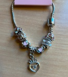 PULSEIRA PRATEADA COM  VARIOS ADORNOS COM EXIBIDA NA FOTO BÉLISSIMA!!