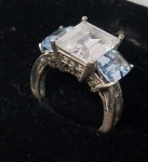 Anel antigo em prata e pedras translúcias, sendo uma central maior e pequenas nas laterias e duas médias na cor azul clara. Aro 10. Prat 925. Peso 4.4 g com as pedras.