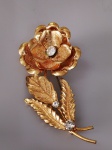 anos 50 - Brochê em metal na cor ouro, com detalhe em pedra tranlúcida , representando rosa, Medindo 7,5 x 3 cm.