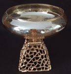 Belo Centro de mesa decorativo, sendo o bojo em vidro e a base em metal dourado com vazados . Medindo 18 cm e a boca na parte superior 15 cm de diâmetro.