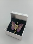 Belíssimo Broche , representando Borboleta envolvido por uma cobra , trabalhados em pedra e as assas da borboleta revestido em tecido furta cor e pedrinhas . Medindo : 5 x 5 cm