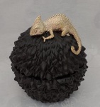 Exótico potiche  trabalhado em relevo  na cor preta encimado por lagarto com patina dourada. Medindo 17 cm de altura X 13 cm de largura aproximadamente.