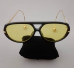 Belissimo Óculos aviador com brinco moderno grande na ponta , na cor preta e lente amarela .