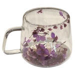 Caneca com alça de vidro borossilicato com flores secas inseridas na parede dupla. Capacidade: 200 ml. Medindo 8 cm de diâmetro e 8 cm de altura.