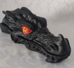 Incensário cabeça de dragão super exótico, confeccionado em resina na cor preta, para suporte de incenso. Excelente acabamento, rico em detalhes e com a pintura realizada a mão. Medidas: Altura: 9 cm. Largura: 8 cm. Comprimento: 24 cm.