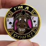 COLECIONISMO - Moeda decorativa em metal dourado, com símbolos de naipes, policromada e  esmaltada, com a frase "I'M A DONK". Medindo aproximadamente 4 cm de diâmetro x 0.03 cm de espessura. Pesando 28 gramas Acompanha case.