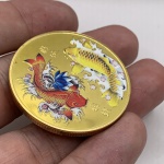 Moeda decorativa com Carpas Koi em metal dourado com case de acrílico. Diâmetro: 4 cm. Espessura: 0,3 cm.