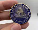 Moeda decorativa da Maçonaria em metal com case de acrílico. Diâmetro: 4 cm. Espessura: 3 cm.