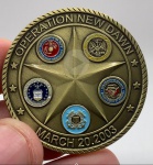 Moeda comemorativa Operação New Dawn São Jorge em metal acompanhando case de acrílico. Diâmetro: 4 cm. Espessura: 3 cm.