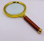 Lupa de mão, lente de vidro, zoom 70mm e cabo de madeira. Medindo 15,5 cm x 8 cm.