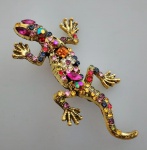 Broche em metal dourado representando Lagartixa policromada e toda trabalhado em pedrinhas multicoloridas . Medindo 6,5 x 4 cm.