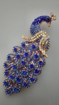 Exuberante broche em metal na cor dourada representando Pavão , todo trabalhado com pedrinhas, nas cores azul  .. Medindo : 9x4  cm . Linda peça.