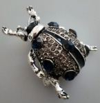 Broche em metal na cor prata representando BESOURO, trabalhado em pedrinhas , nos tons escuros . Medindo 4,5x4 cm.