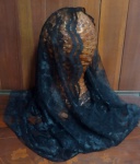 Cachecol em renda na cor preta , fechado ; pode ser usado como véu para Igreja .
