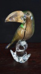 Magnífica Estátua de tucano de Murano , rica em pó de ouro e com veios verdes , violetas e azuis , sobre uma base de vidro transparente . Medindo : 29 x 18 cm .